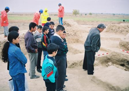 The teacher from Kazanbulaq school looking at a grave in Borsunlu kurgan